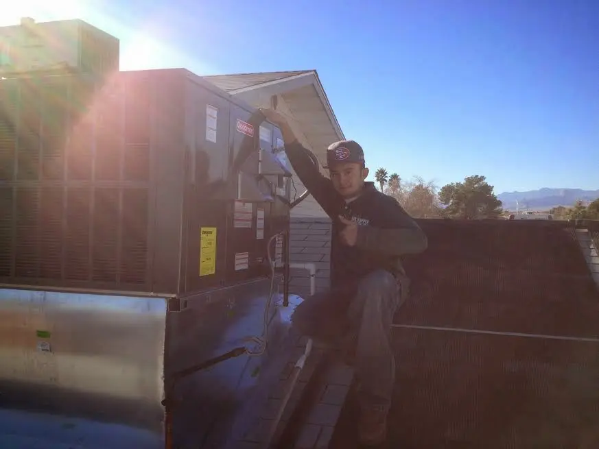 HVAC technician performing AC Tune-Up on a rooftop unit in Mililani Mauka